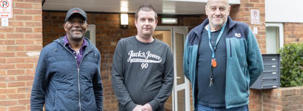 Two Hightown staff members and a resident standing outside a homeless service