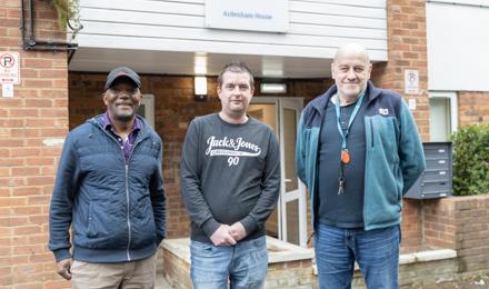Two Hightown staff members and a resident standing outside a homeless service