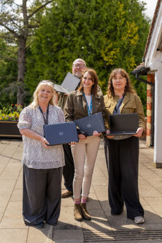 Group of people standing holding laptops