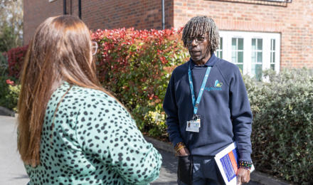 A resident is talking outside with her property services inspector.