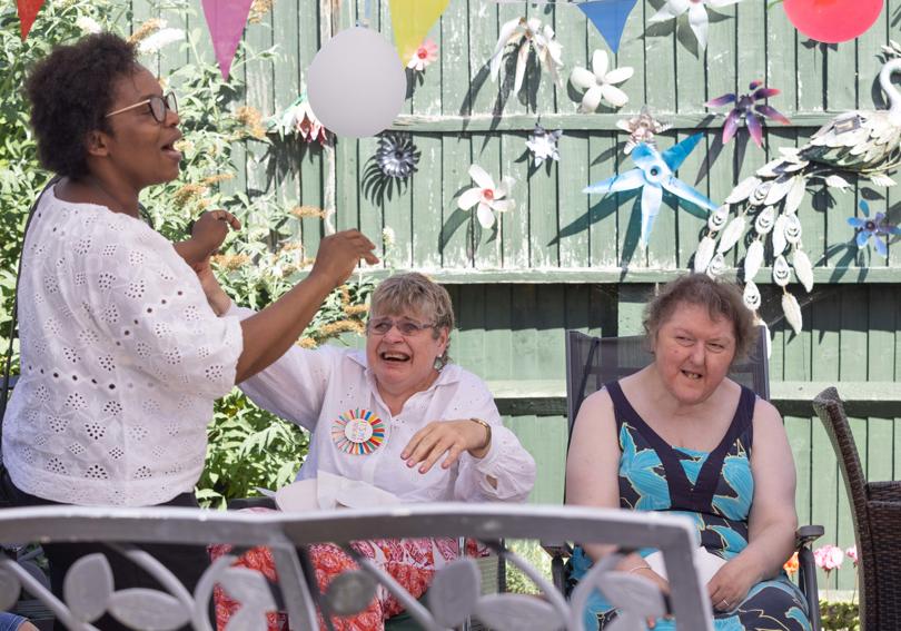 Three people singing and smiling in the sun