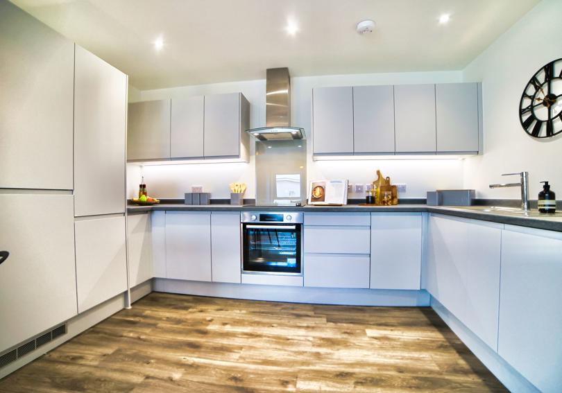 Fully fitted kitchen with integrated appliances and handless grey units