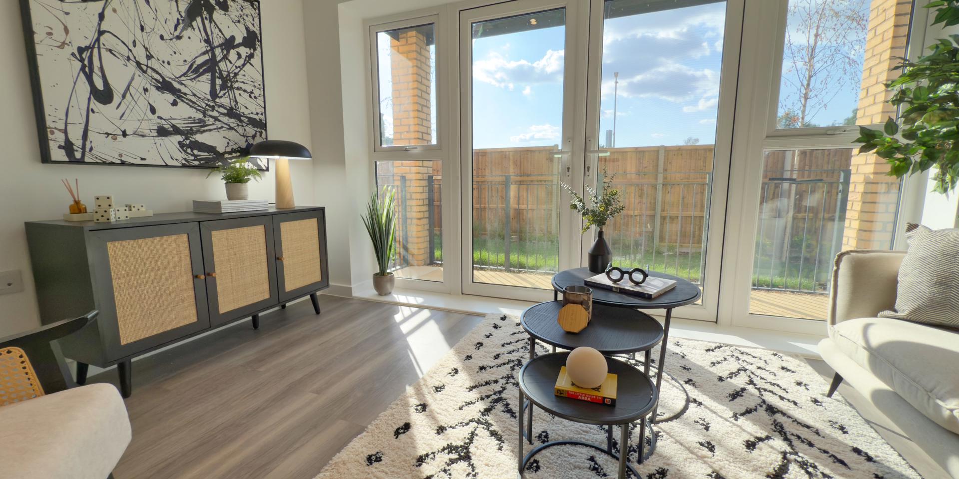 There are double patio doors with windows attached. There is a 2-seater sofa, chair, side table and coffee tables in the living area