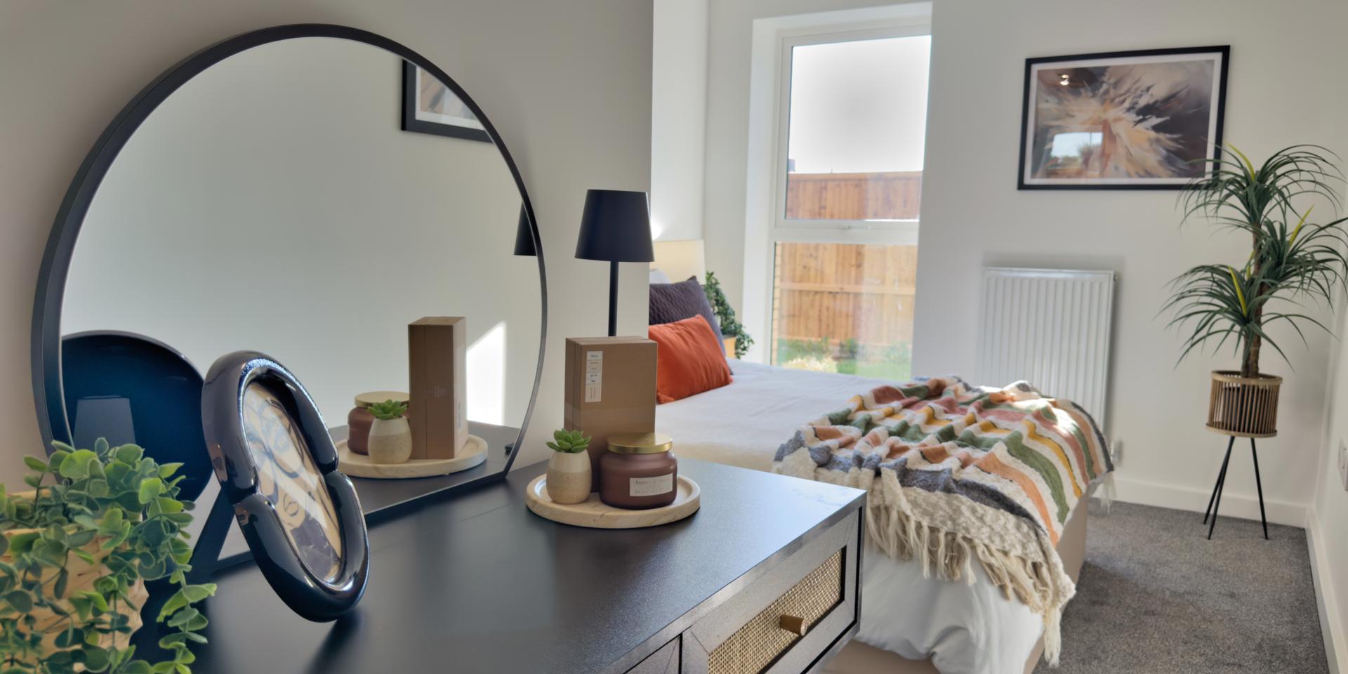 There is a large window which goes from the floor and almost to the ceiling. There is a dressing table and built-in double mirrored wardrobe