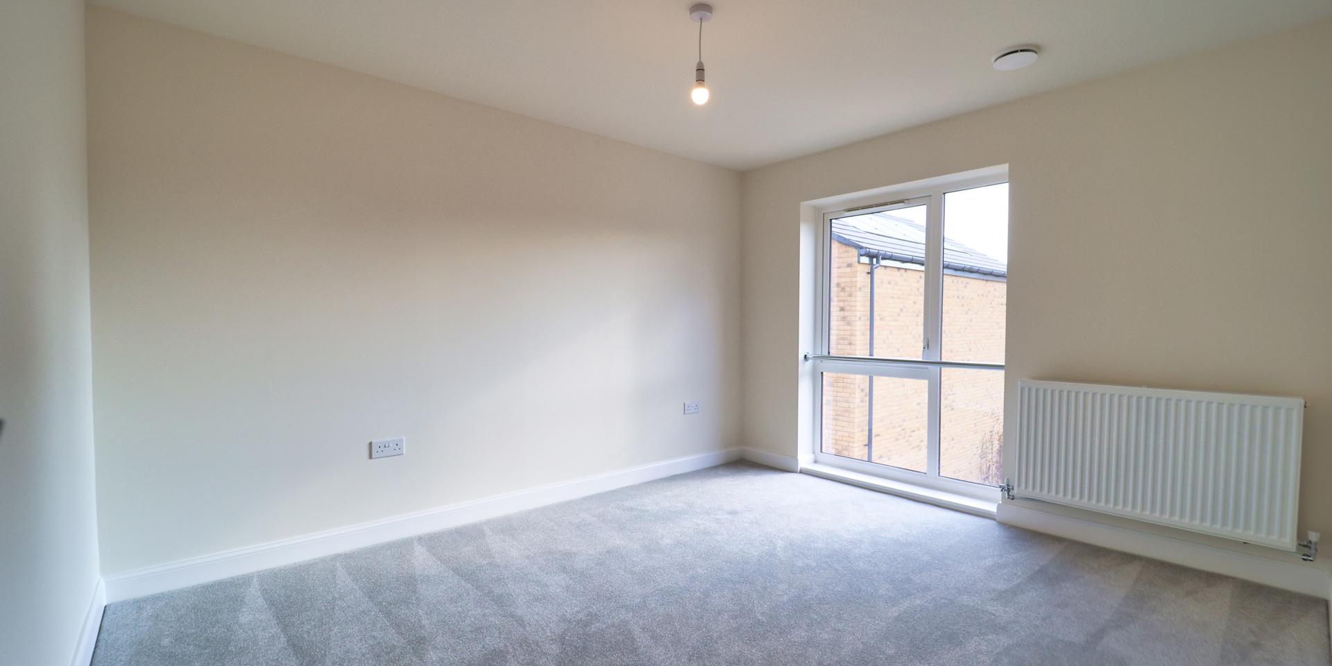 A double bedroom with a very large window which goes from the floor to almost the ceiling