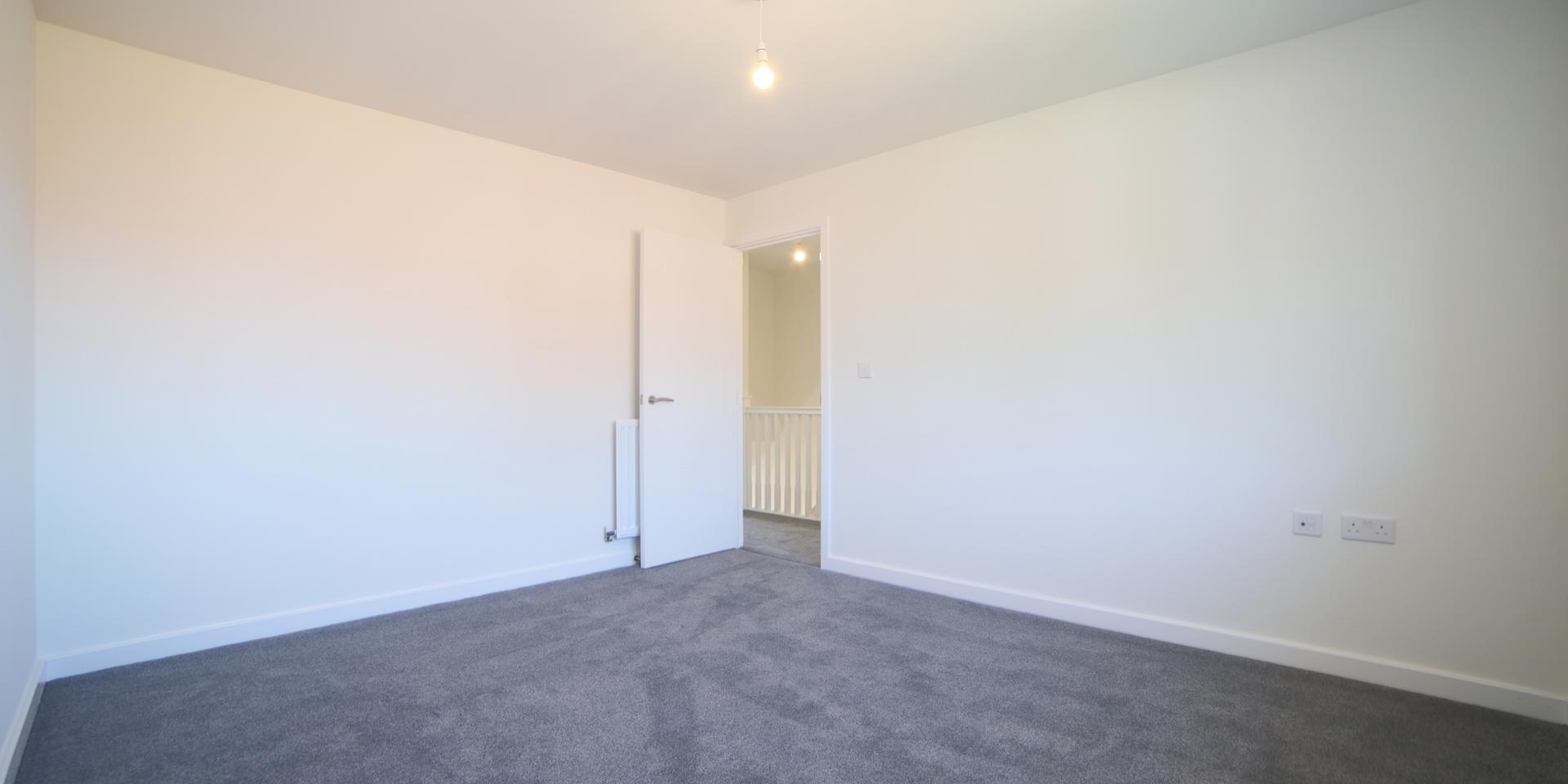 Bedroom one is a large double room with grey carpet