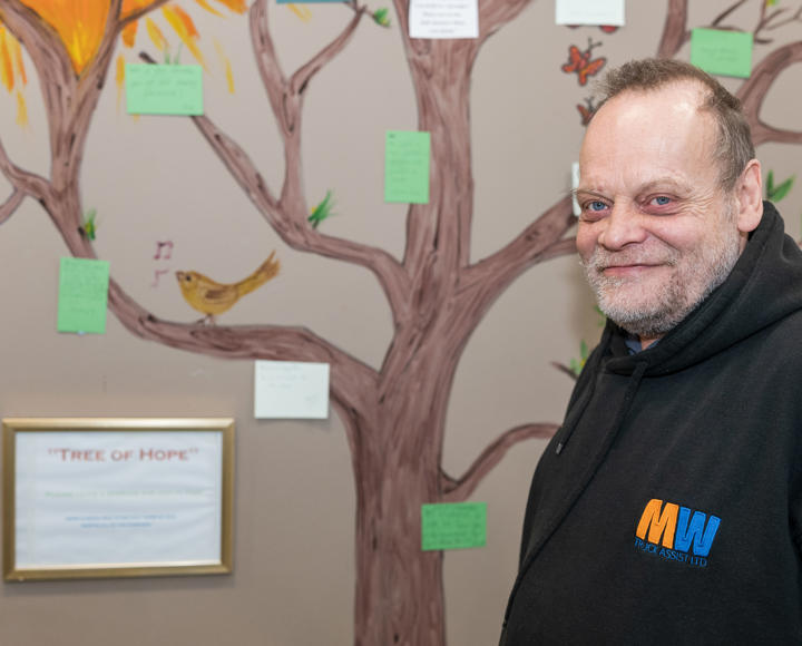 A service user standing next to a project at a scheme