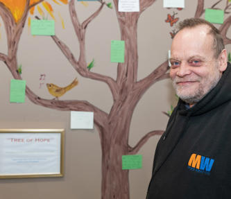 A service user standing next to a project at a scheme