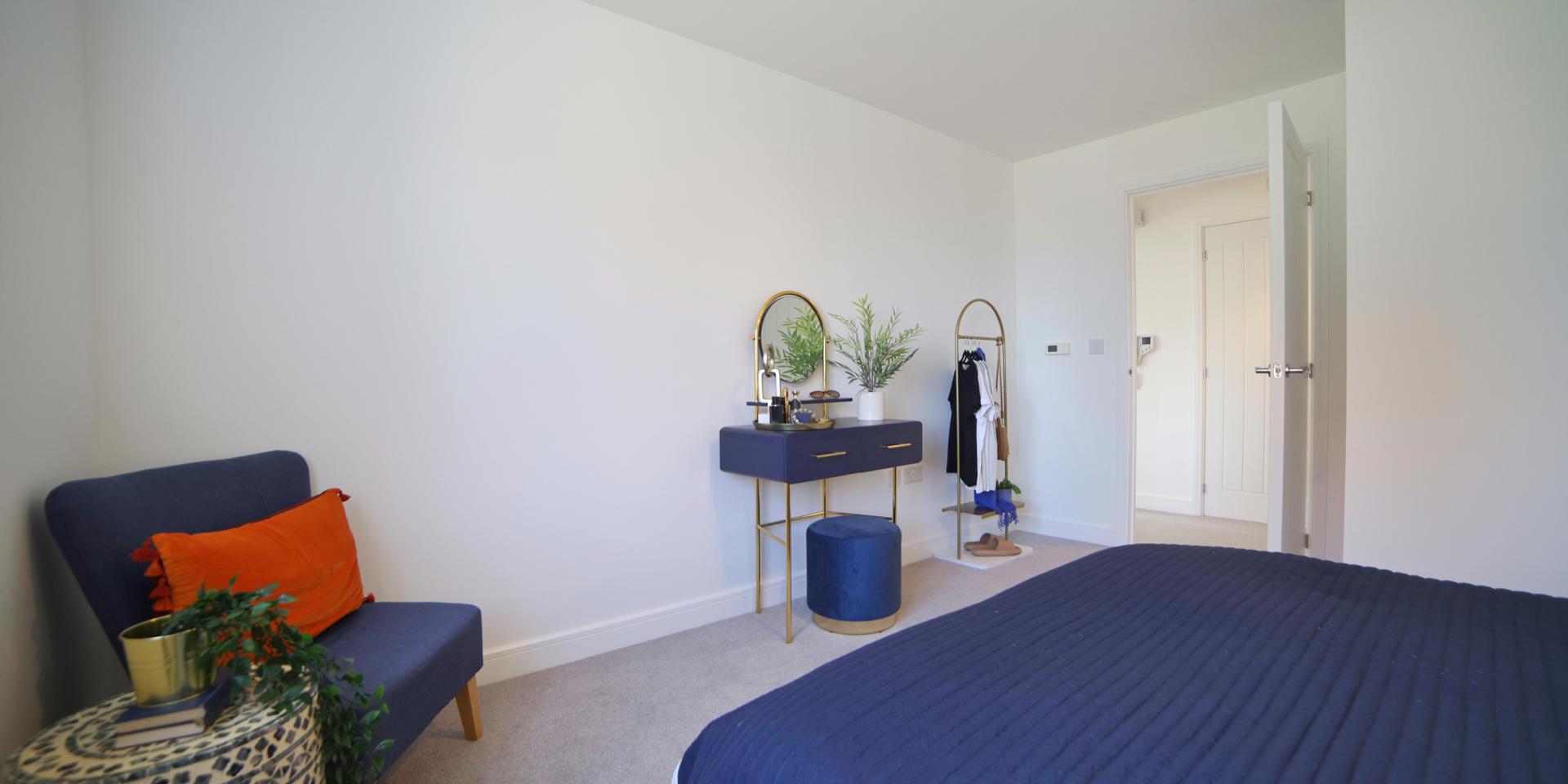 In the corner of the bedroom is a single chair, washing basket plus the dressing table, freestanding clothes rail and stool.