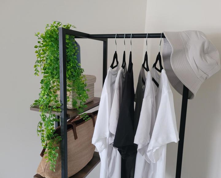 A clothes rail with white tee shirts hanging on it