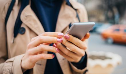 Woman using mobile phone on street
