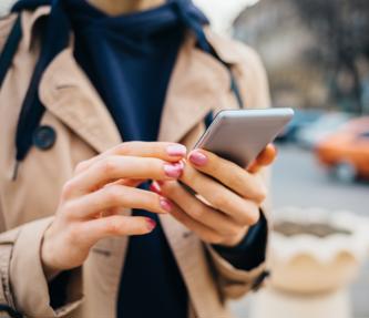 Woman using mobile phone on street