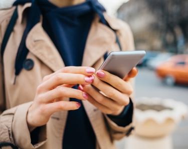 Woman using mobile phone on street