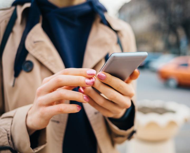 Woman using mobile phone on street