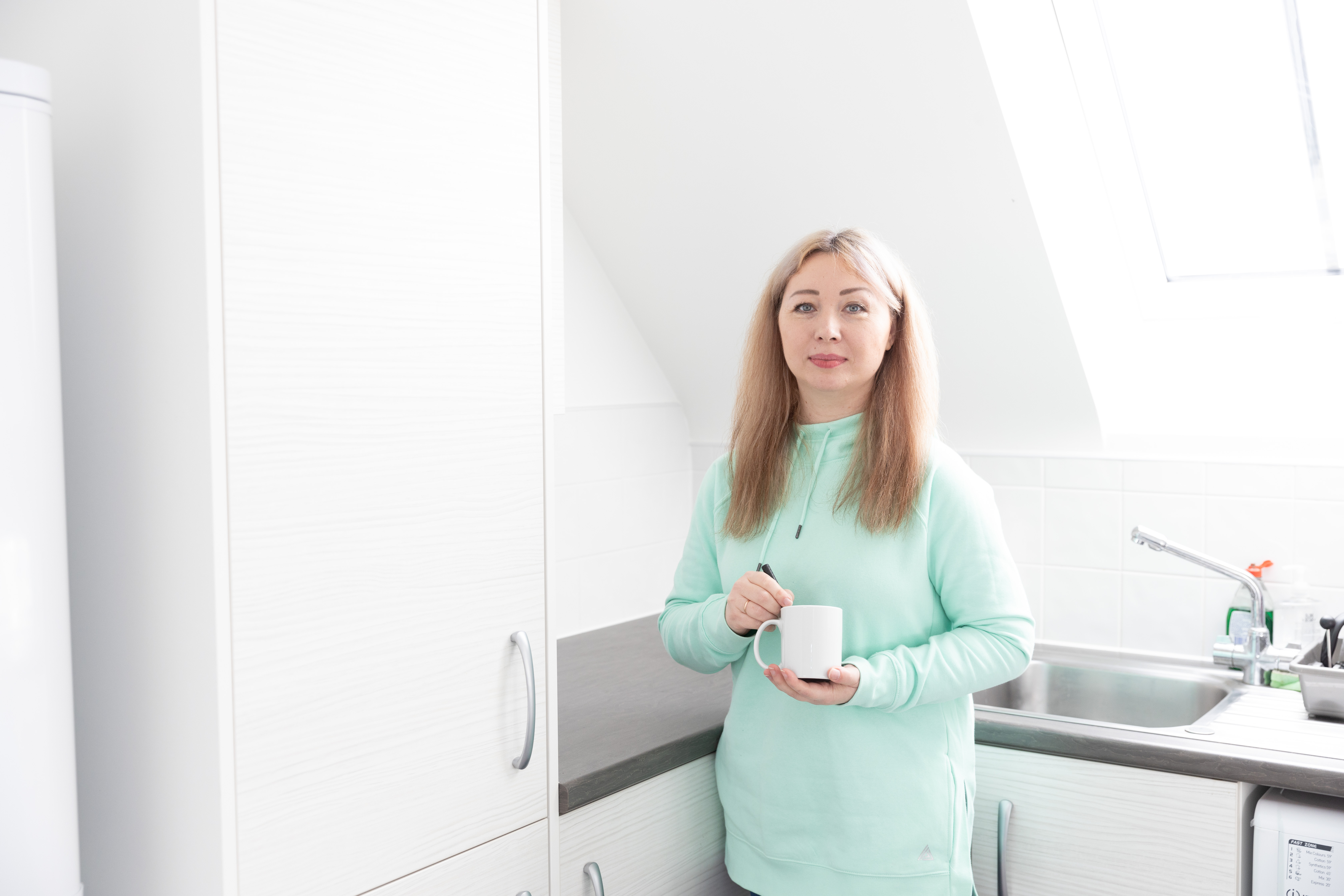 A Hightown resident holding a cup of tea in their home. 