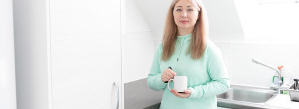 A Hightown resident holding a cup of tea in their home.