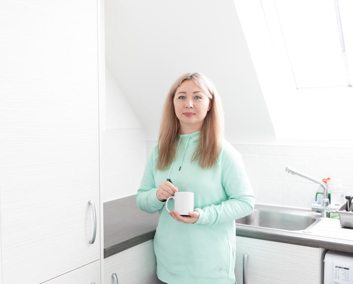 A Hightown resident holding a cup of tea in their home.