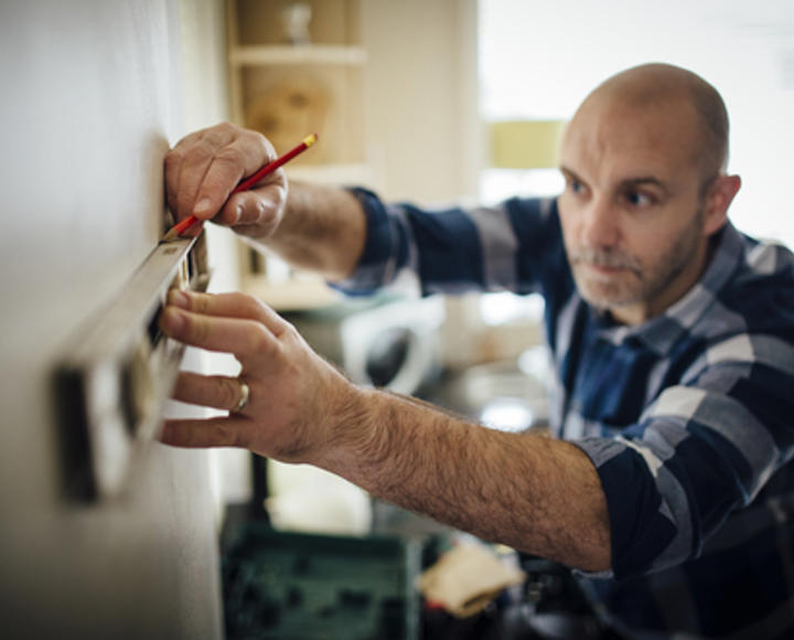 A man using a spirit level for building works