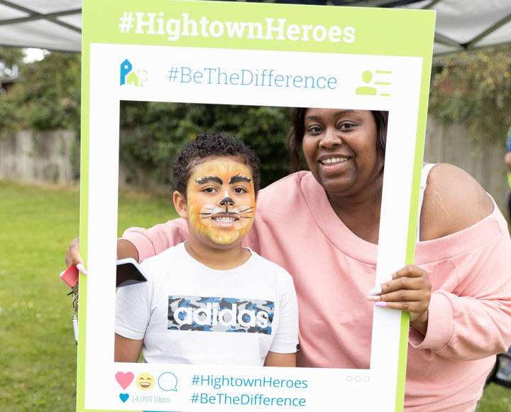 Hightown resident and her son in facepaint and posing with a selfie frame at a summer resident involvement event