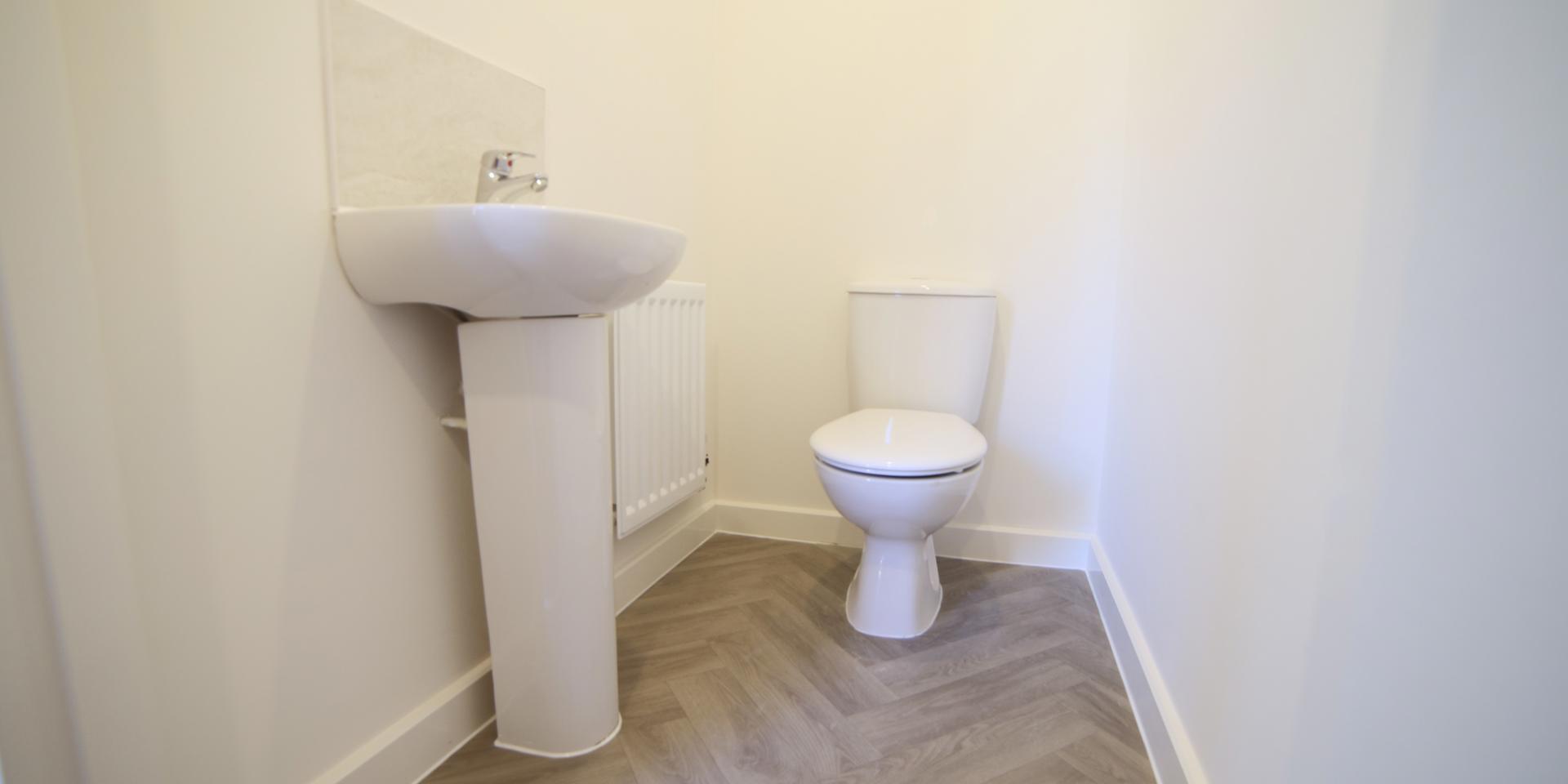The cloakroom has a white toilet and sink