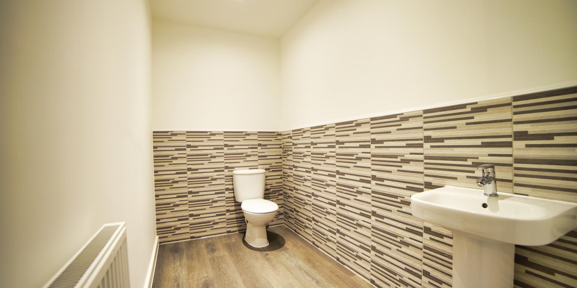 Downstairs cloakroom with white toilet and wash hand basin