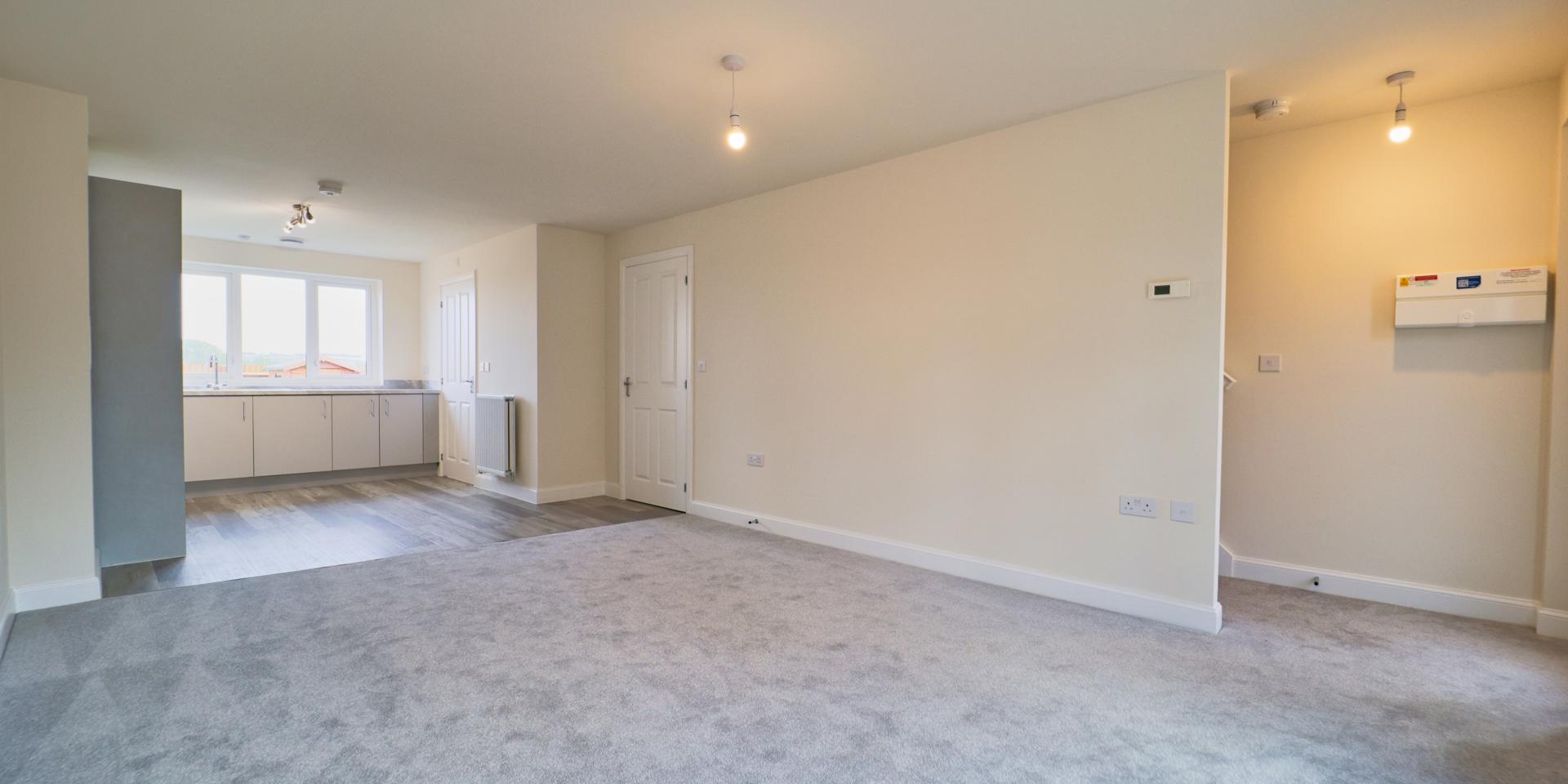 The hall is open plan to the living area and the stairs are hidden behind a wall.