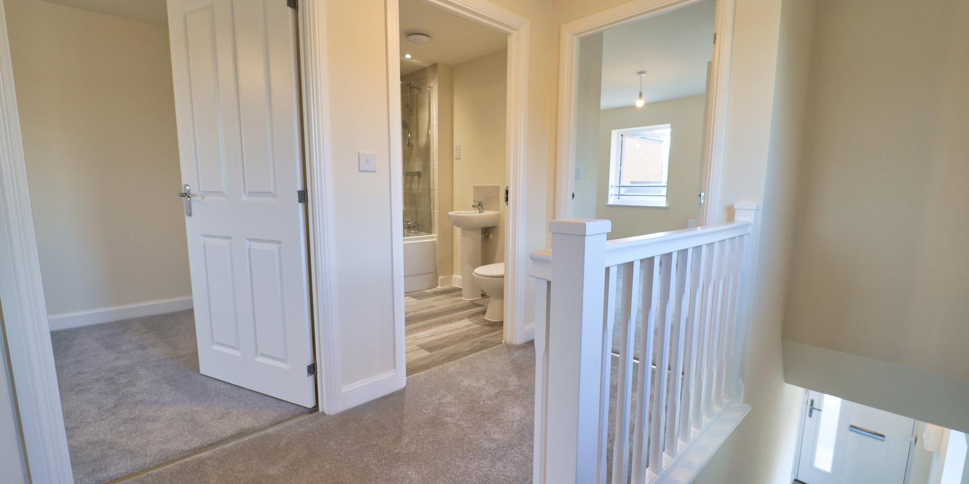 There is a small landing with a banister at the top of the stairs