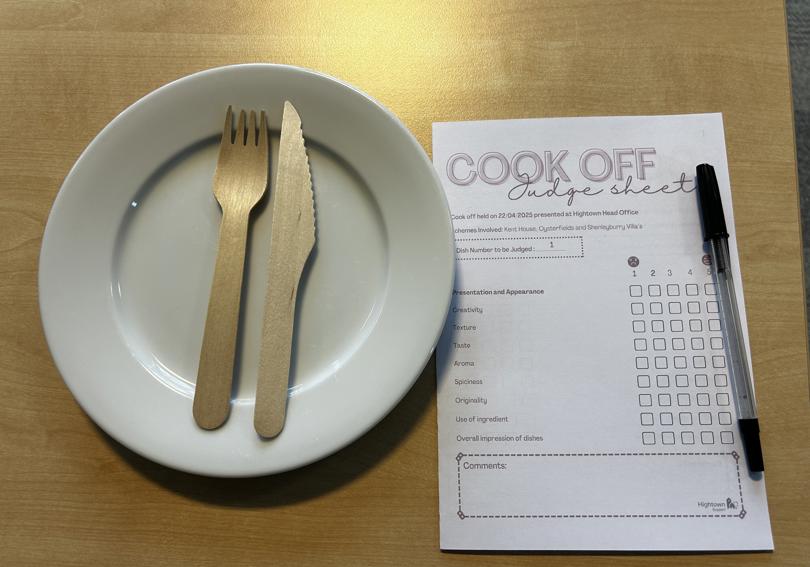  A picture of a plate, a knife and fork, and a score card for the cook off