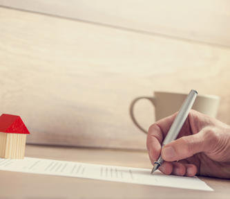 Someone filling in a form on a piece of paper to extend their lease for their shared ownership property