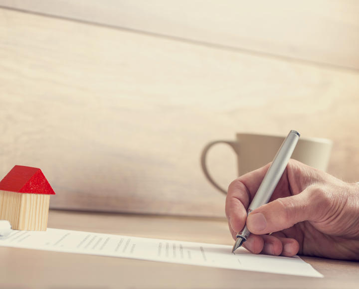 Someone filling in a form on a piece of paper to extend their lease for their shared ownership property