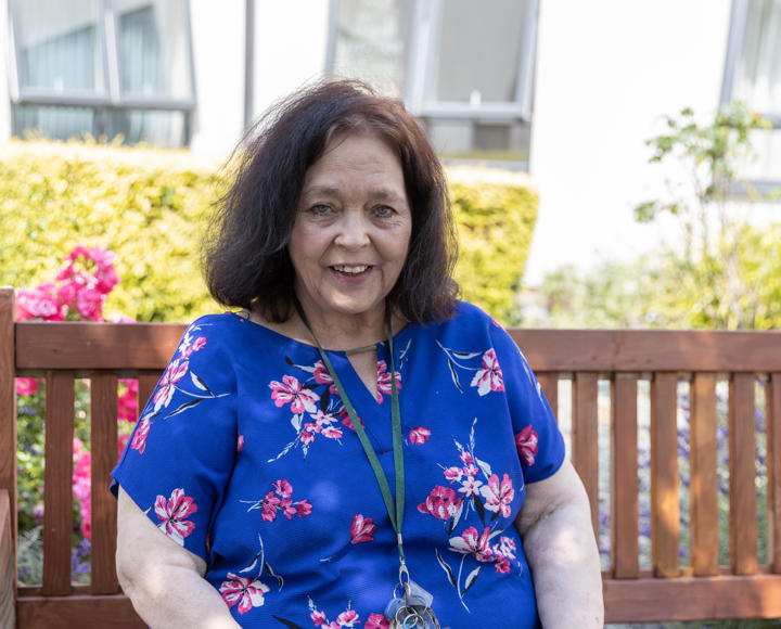 A service user from a care and supported housing scheme sat outside on a bench