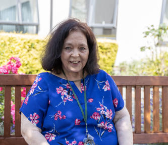 A service user from a care and supported housing scheme sat outside on a bench