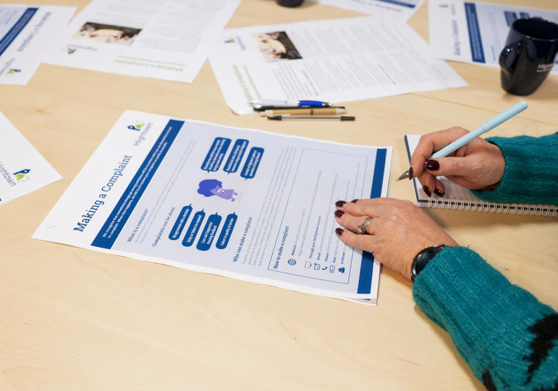 Hightown staff member reviewing complaints leaflet at Hightown House