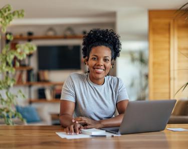 Woman sat at a desk applying for a job on her laptop.