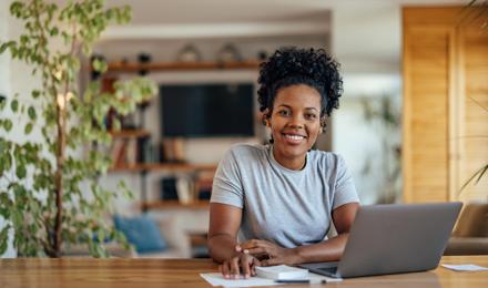 Woman sat at a desk applying for a job on her laptop.