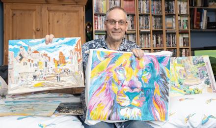 Hightown service user shows his colourful painting of a lion, amongst other paintings