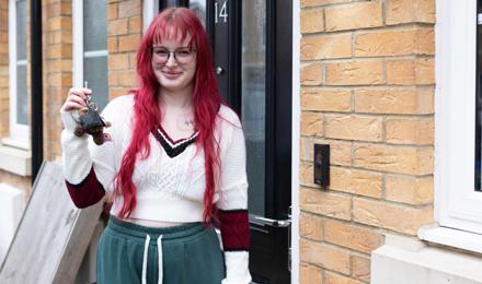 Shared Owner standing outside her front door holding the keys and smiling