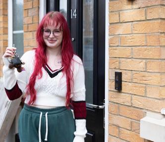 Shared Owner standing outside her front door holding the keys and smiling