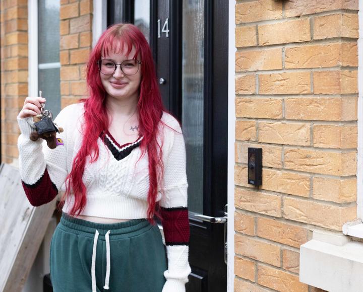 Shared Owner standing outside her front door holding the keys and smiling