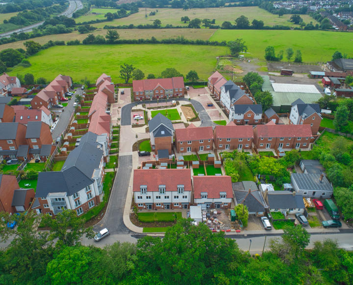 Drone photo of a big housing development surrounded by fields.