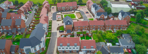 Drone photo of a big housing development surrounded by fields.