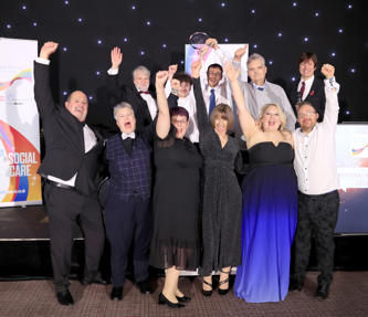 Staff and service users celebrating winning an award, dressed up in black tie 