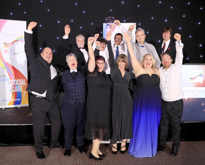 Staff and service users celebrating winning an award, dressed up in black tie 