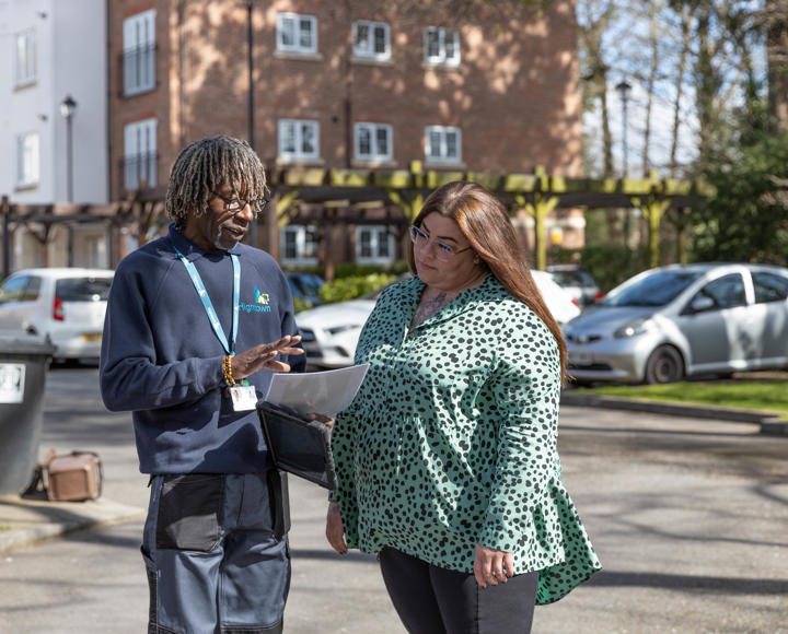 Resident and property services inspector are outside talking through notes.