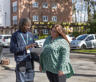 Resident and property services inspector are outside talking through notes.