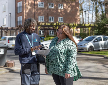 Resident and property services inspector are outside talking through notes.