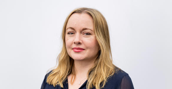 Headshot of Sarah Barton, member of Hightown's board. She is wearing a navy blouse and has long blonde hair and blue eyes.