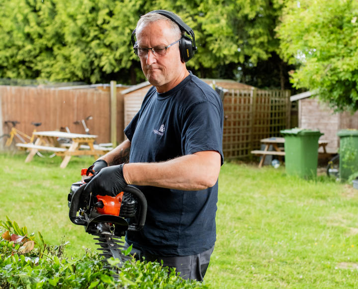 A caretaker is trimming the hedge on a Hightown estate.
