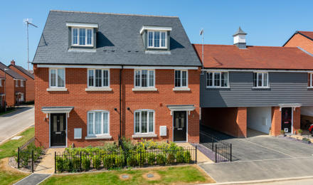 Two houses with a fence and front garden.