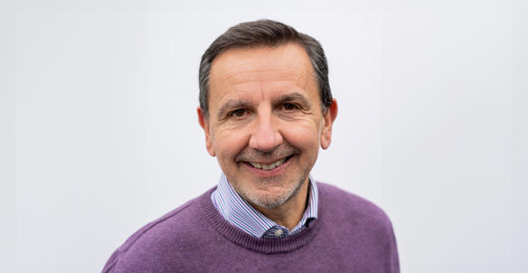 Headshot of Andrew Royall, Director of Development. He is wearing a purple jumper and a purple, white and blue striped shirt.